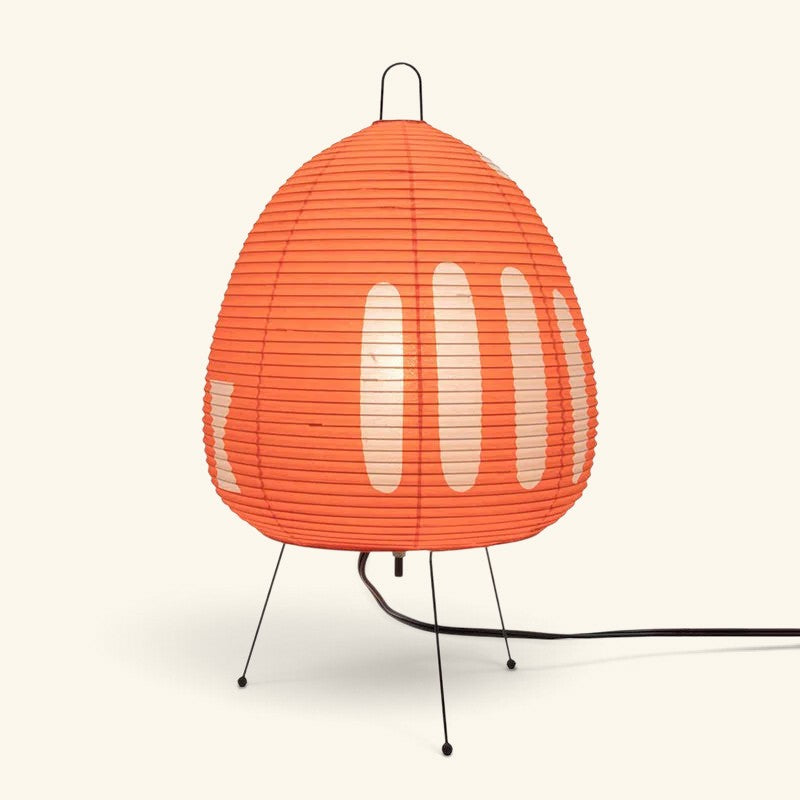 Lampe Maison Lumari style Akari en papier de riz orange avec motifs blancs et pied trépied en métal noir